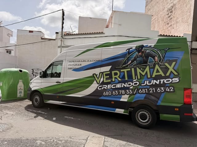 Furgoneta Vertimax rotulada en verde y azul, vista lateral